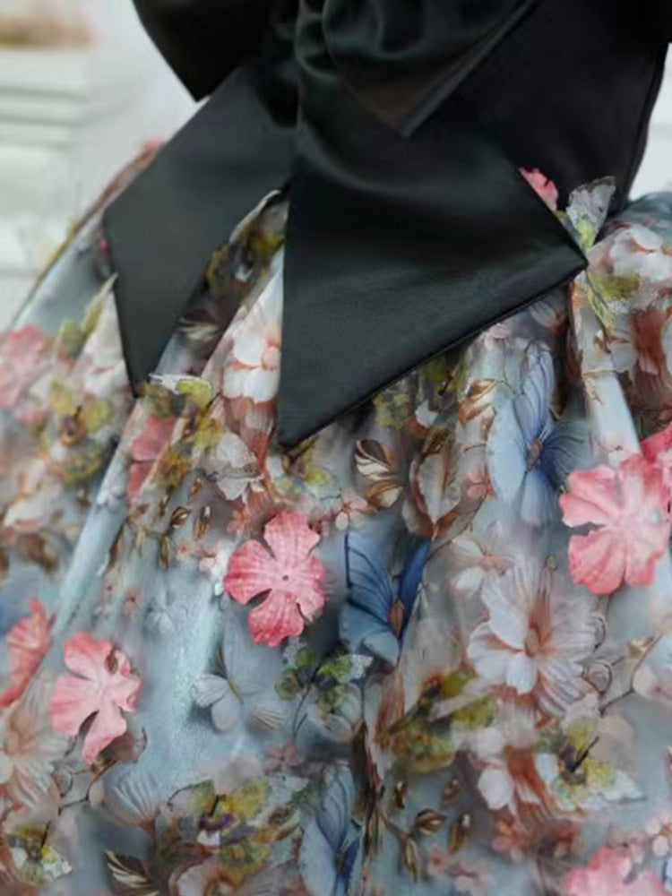 Black satin bow and 3D floral skirt detail of a girls party dress, designed for birthday parties and photoshoots.