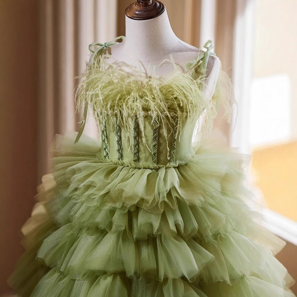 Close-up of the feather trim and tie straps on the bodice of the sage green flower girl dress.