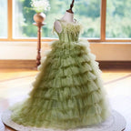 Sage green tiered tulle gown photographed by a window, angled view, for a garden ceremony.