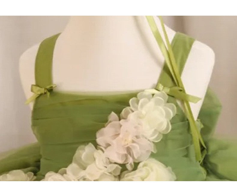 Close-up of the flat shoulder straps and tiny ribbon bows on the sage green flower girl dress.