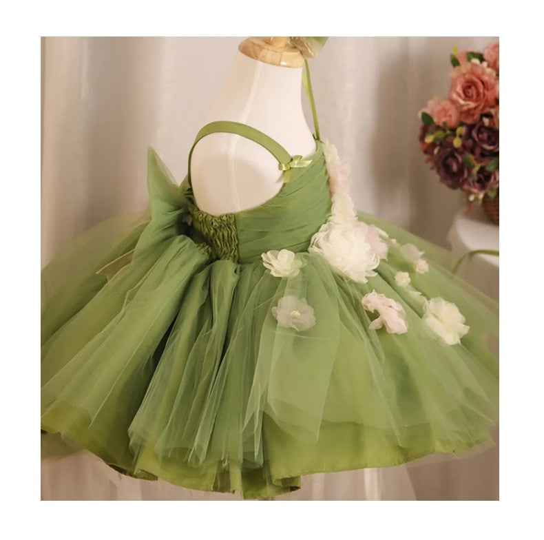 Side angle of the sage green tulle girls formal dress with ribbon shoulder ties and scattered ivory flowers, view 2.