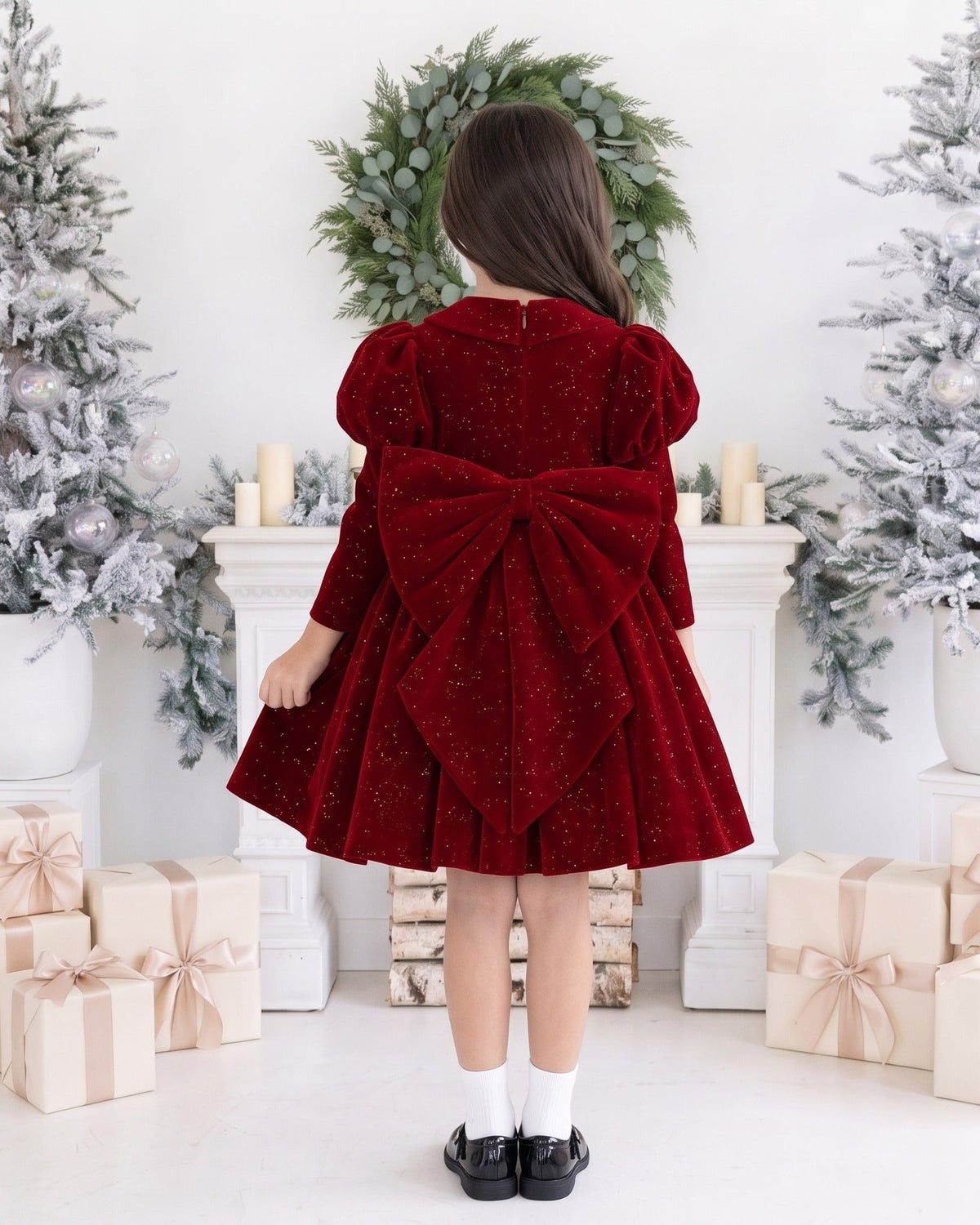 Back of the burgundy velvet girls Christmas dress showing the large velvet bow with long tails at the waist.