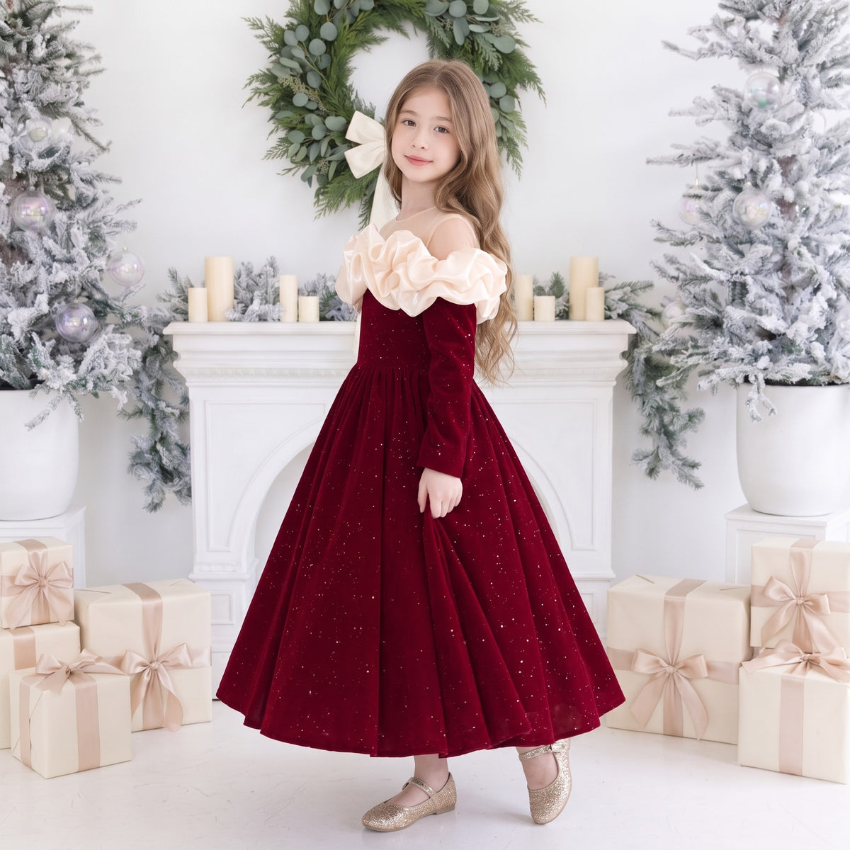 Side view of a girls red velvet ball gown with puffy ivory ruffles over the shoulders and a full sparkle skirt