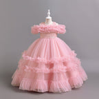 Pink tulle girls ball gown with ruffled off-shoulder band, lace waist and tiered ruffle skirt, designed for flower girls and weddings.