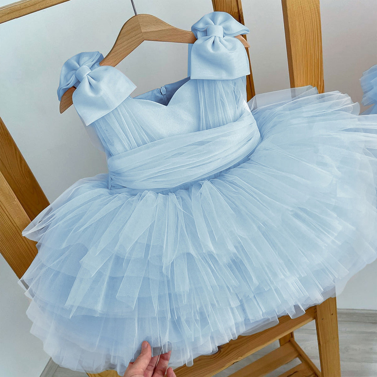 Light blue tulle princess dress for girls with a sweetheart neckline and ruffled tiers, front view, for a flower girl at a wedding.