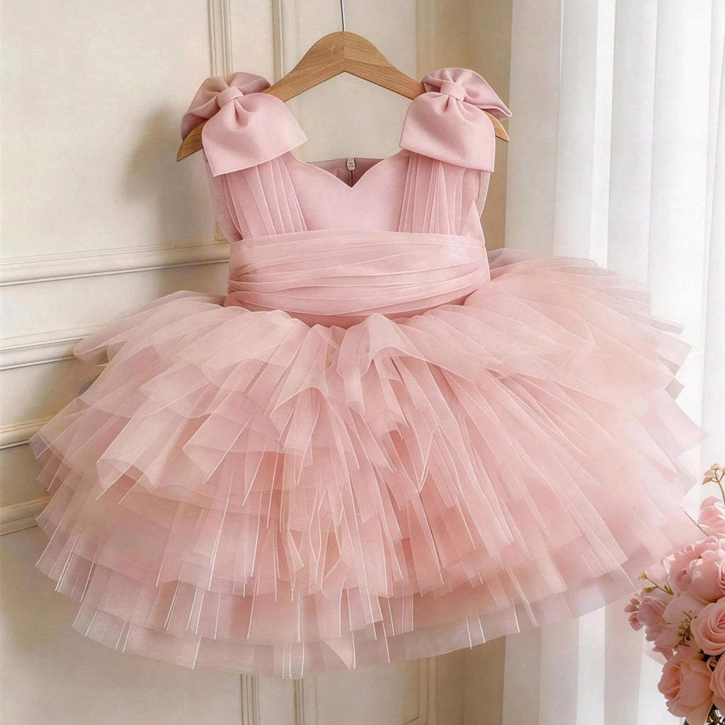 Pink tulle girls party dress with bow shoulder straps and a tiered tutu skirt, front view, for a birthday party.