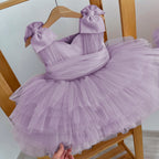 Purple tulle princess dress for girls with oversized shoulder bows and a pleated waist sash, front view, for a party.