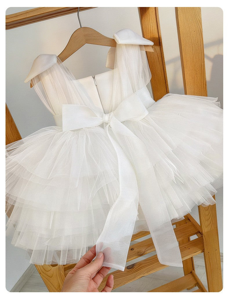White dress for girls in tulle showing the back closure and the organza sash bow.