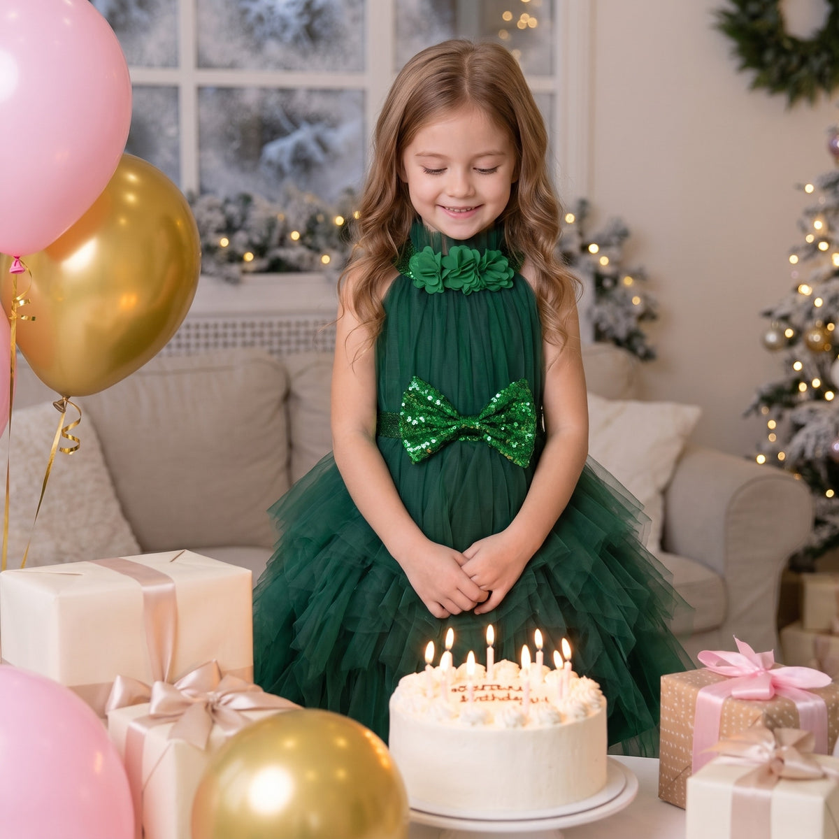 Girl in a dark green tulle princess dress with a sequin bow standing by her winter birthday cake.