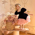 Black and pink girls party dress with velvet puff-sleeve bodice and 3D rosette mini skirt, front view, for birthday parties.