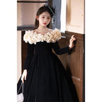 Black velvet girls formal dress with the cream ruffled collar off the shoulder, angled view.
