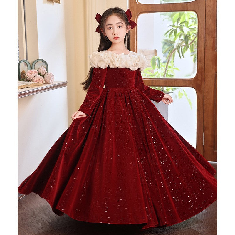 Red velvet girls formal dress with a sweeping full skirt, angled view, for a winter party.