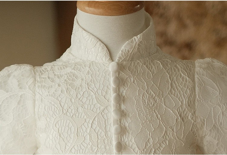Close-up of the mandarin collar and self-covered button placket on the ivory lace flower girl dress.