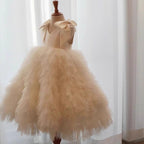 Champagne tulle girls formal dress with a satin V-neck bodice and tiered ruffle ball gown skirt, front view, for weddings.