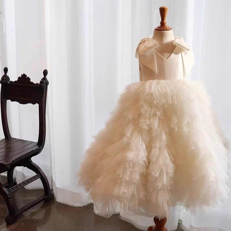Champagne princess dress for girls with a ruffled tulle skirt, styled in a sunlit room beside an antique wooden chair.