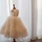 Champagne tiered tulle flower girl dress seen from the side, showing the layered ruffle skirt, for pageants and recitals.