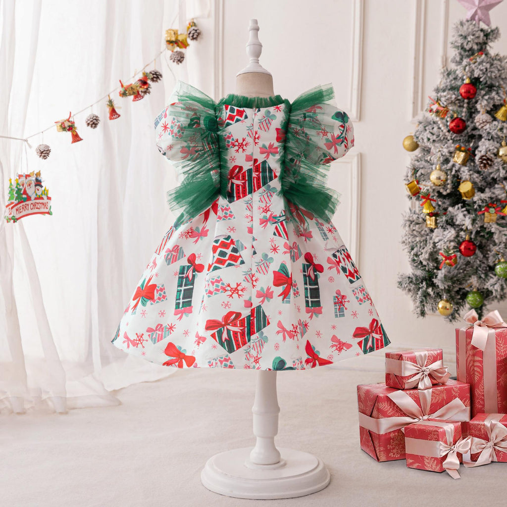 White printed satin girls Christmas dress on a stand with green tulle ruffles and puff sleeves, designed for holiday parties.