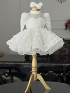 White lace girls princess dress with long sleeves and full rosette skirt, designed for first birthday photos.