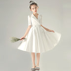 White satin girls dress with a tuxedo lapel collar, puff half sleeves and a full knee-length skirt, designed for weddings and recitals, view 3