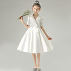 White satin girls dress with a tuxedo lapel collar, puff half sleeves and a full knee-length skirt, designed for weddings and recitals.